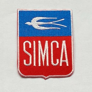 May include: Embroidered patch with a shield design. The top half is blue with a white bird, and the bottom half is red with the white text "SIMCA". The patch has a red border.