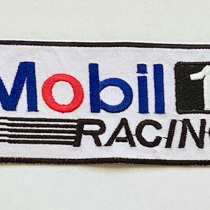 May include: Embroidered patch featuring the Mobil 1 Racing logo. The patch has a white background with the words "Mobil" in blue and red, and "RACING" in black. A black square with a white "1" is on the right.