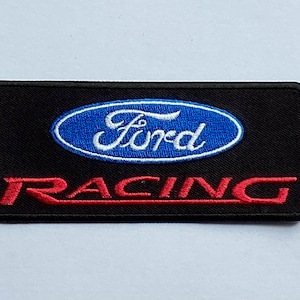 Puede incluir: Parche rectangular negro con el logotipo de Ford en un óvalo azul y escritura blanca. La palabra "RACING" está bordada en rojo debajo. Para entusiastas del automóvil.