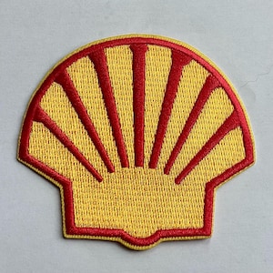 May include: Embroidered patch featuring the Shell logo. The patch has a yellow background with a red outline and red radiating lines. The design is a stylized scallop shell.