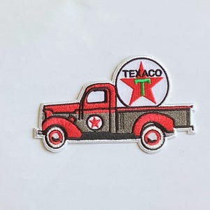 May include: Embroidered patch featuring a vintage red and gray pickup truck with a Texaco logo. The patch has a white border and includes the Texaco star logo and the word TEXACO.
