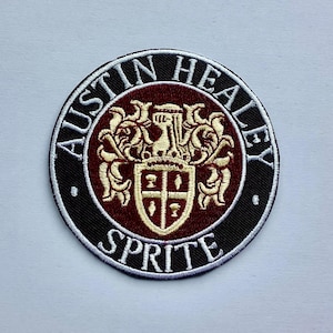 Könnte beinhalten: Runder, gestickter Aufnäher mit dem Schriftzug "AUSTIN HEALEY SPRITE". Der Aufnäher hat einen schwarzen Rand, eine weinrote Mitte und ein goldenes Emblem. Geeignet für Kleidung.