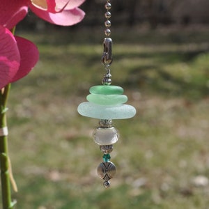 May include: A light green, blue, and white glass bead chandelier pull chain with silver accents.