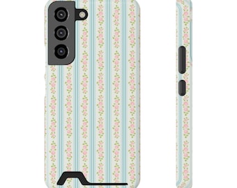 May include: A phone case with a floral pattern. The case features a repeating pattern of pink roses and green leaves on a light blue and white striped background. The case is shown from the front and side.