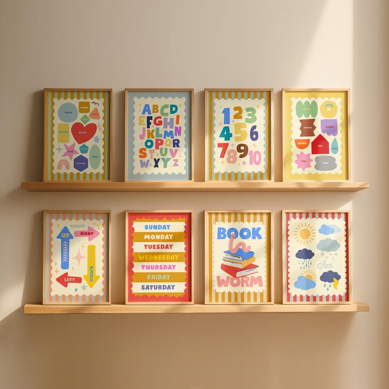 May include: Eight framed art prints with colorful designs and text, including letters, numbers, days of the week, and directional arrows. The prints are displayed on two wooden shelves against a neutral wall.