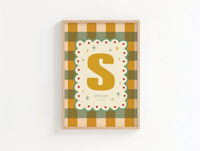 Puede incluir: Un estampado enmarcado con la letra "S" de color amarillo mostaza sobre un fondo crema, con un borde festoneado. El fondo es un patr&oacute;n de cuadros en tonos amarillos, verdes y crema. El nombre "Spencer" y una fecha est&aacute;n impresos debajo.