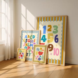 May include: Four framed art prints with colorful designs. One print features the numbers 1-10, another the alphabet, and a third with shapes and a heart. The smallest print has a house and other shapes.