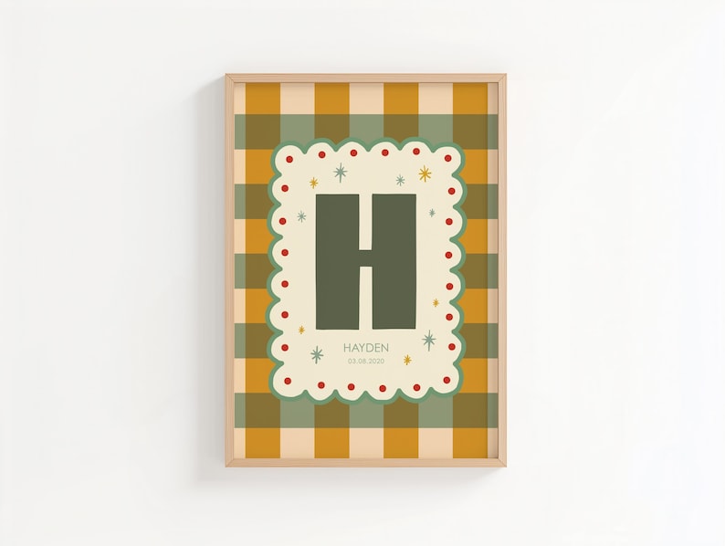 Puede incluir: Un estampado enmarcado con un fondo a cuadros verde y amarillo. El estampado tiene un borde decorativo con puntos rojos y estrellas, que enmarca una gran letra "H" verde. El nombre "Hayden" y una fecha est&aacute;n impresos debajo.