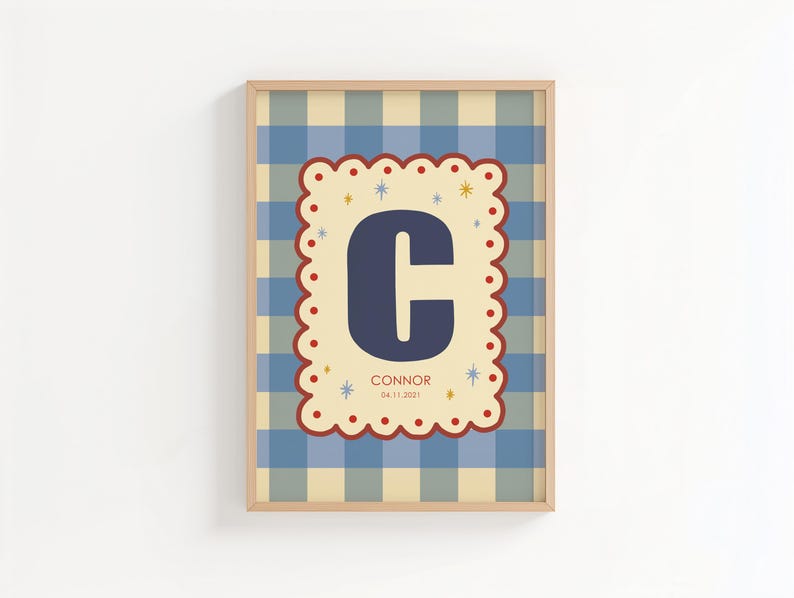 Puede incluir: Cuadro enmarcado con un fondo a cuadros azul y beige. Un dise&ntilde;o central con bordes festoneados muestra la letra "C" azul marino, el nombre "Connor" y la fecha "04.11.2021". El marco es de color madera clara.