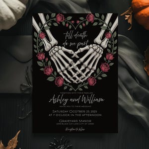 Op de afbeelding: Zwarte trouwkaart met skelet handen die een hart vormen, omringd door rode rozen. De tekst luidt "Till death do we part" en nodigt gasten uit voor de bruiloft van Ashley en William op 25 oktober 2025 in Graveyard Manor.
