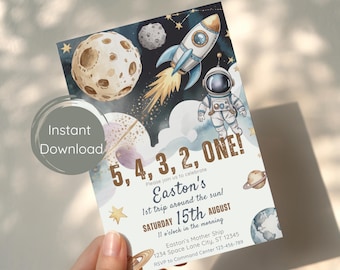 Può includere: Invito a tema spaziale, con un design ad acquerello. Raffigura un razzo, un astronauta, pianeti e il testo "5, 4, 3, 2, ONE!" e "Easton's 1st trip around the sun!". Include data, ora e luogo.