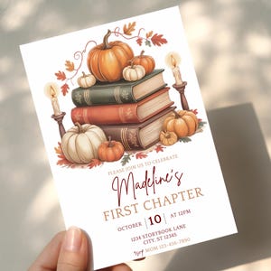 May include: An invitation card with a watercolour illustration of pumpkins, books, and candles. The text reads "Madefine's First Chapter" with the date October 10th at 12 PM. The card has an autumnal theme.