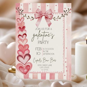 May include: A pink and white Galentine's Party invitation with a bow and hearts. The invitation includes the text "Join us for a Galentine's Party" and event details. A lit white candle and heart-shaped decorations are in the foreground.