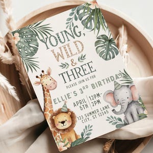 以下が含まれることがあります： ジャングルをテーマにした誕生日招待状。招待状には「Young, Wild & Three」の文字と、キリン、ライオン、ゾウのイラストが描かれています。招待状には日付、時間、場所が記載されています。