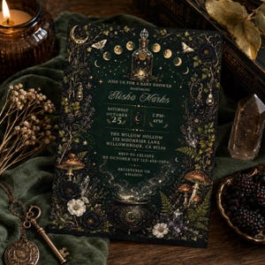 May include: A rectangular baby shower invitation card with a dark green background featuring gold celestial and botanical illustrations, including a potion bottle, a cauldron, mushrooms, and moon phases, with white text detailing event information.