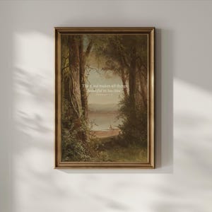 May include: A framed print of a painting depicting a forest scene with a lake in the distance. The quote "The Lord makes all things beautiful in his time. Ecclesiastes 3:11" is printed on the print.