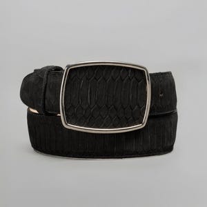May include: A black belt with a textured snakeskin pattern. The belt features a large, rectangular silver buckle. The leather belt is a classic accessory.