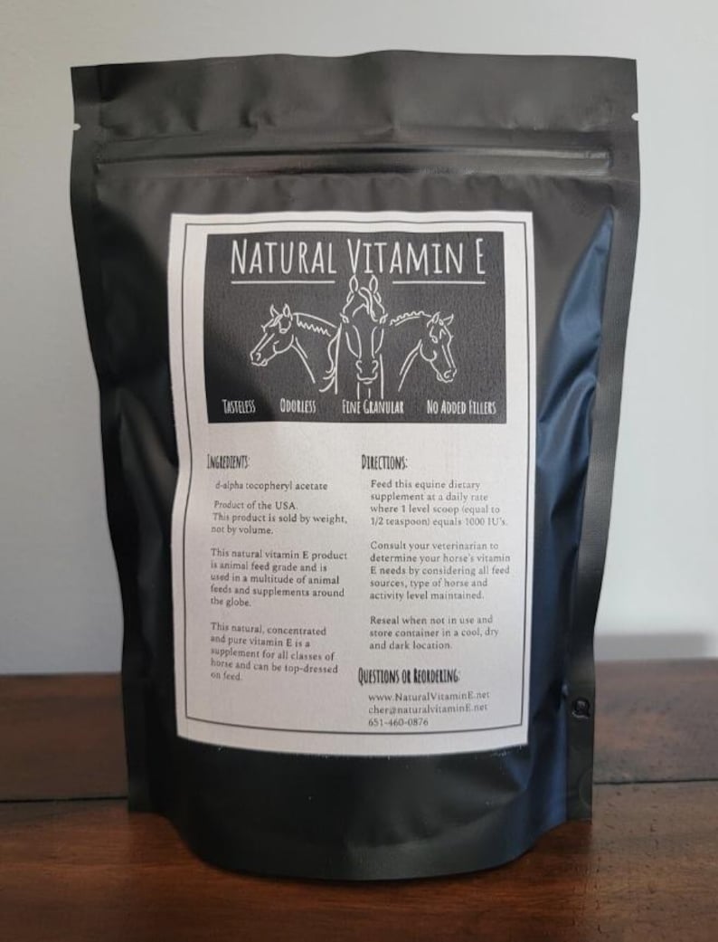 May include: A white bag with a black zipper closure. The bag contains a natural vitamin E supplement for horses. The bag has a label with the words "Natural Vitamin E" and a picture of three horses. The label also includes the words "Tasteless", "Odorless", "Fine Granular", and "No Added Fillers".