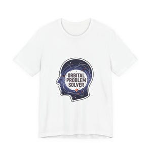 Può includere: T-shirt bianca con una grafica di una silhouette di testa umana riempita con un design a notte stellata. Il testo "ORBITAL PROBLEM SOLVER" è visualizzato in un cerchio all'interno della testa.
