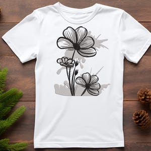 Puede incluir: Camiseta blanca con un dise&ntilde;o floral en blanco y negro. El dise&ntilde;o presenta tres flores con un aspecto estilizado y esbozado.