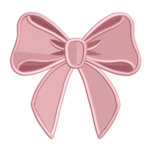 Può includere: Un fiocco rosa chiaro con un design ricamato dettagliato. Il fiocco presenta un nodo centrale e due anelli su ogni lato, con un aspetto strutturato. I bordi sono delineati con un filo rosa più scuro.