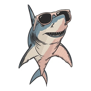 May include: Embroidered shark illustration wearing pink sunglasses. The shark is colored in shades of blue, pink, and cream, with detailed stitching. The shark's mouth is open, revealing sharp teeth.