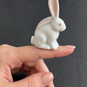 May include: A set of three ceramic mugs with a speckled, matte finish. The mugs are in shades of cream, light gray, and dark gray. Each mug has a simple, minimalist design and a rounded handle.