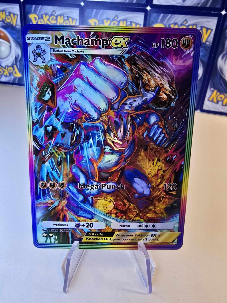 May include: A holographic Machamp EX Pok&eacute;mon trading card. The card features a dynamic illustration of Machamp in action, with a blue and orange color scheme. The card has the text "Mega Punch" and "HP 180".