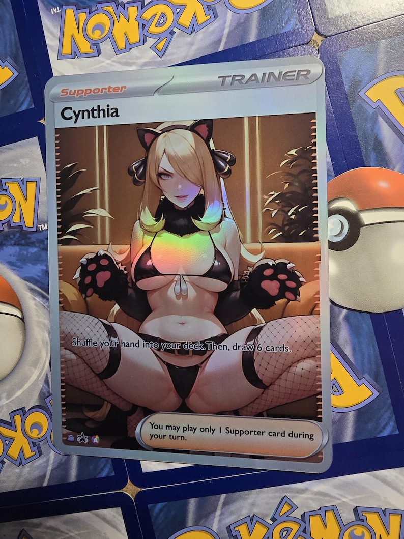 Op de afbeelding: Een holografische "Cynthia" Trainerkaart uit het Pok&eacute;mon Trading Card Game. De kaart toont een anime-stijl illustratie van een vrouw in een zwarte outfit met kattenoren. Tekst op de kaart bevat "Supporter" en spelinstructies.
