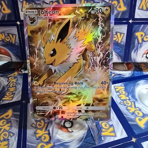 May include: A holographic Pok&eacute;mon card featuring Jolteon, a yellow electric-type Pok&eacute;mon. The card displays the text "Jolteon" and "Beginning Bolt", along with attack details and HP. The background is a mix of yellow and electric effects.