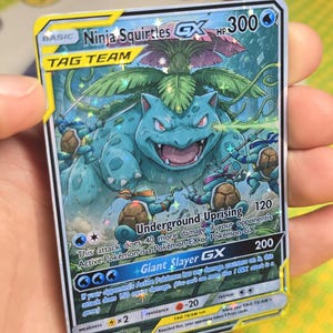K&ouml;nnte beinhalten: Eine Pok&eacute;mon-Sammelkarte mit "Ninja Squirtles GX", einer blau-gr&uuml;nen Illustration eines gro&szlig;en, schildkr&ouml;tenartigen Wesens und kleineren Kreaturen. Die Karte enth&auml;lt Text mit HP, Angriffen und anderen Spieldetails.