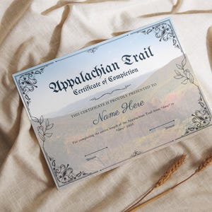 Puede incluir: Un certificado de finalización para el Appalachian Trail, que presenta un paisaje montañoso escénico con un cielo azul y nubes blancas. El certificado está impreso en un fondo blanco con texto negro y un borde decorativo. El texto dice "Appalachian Trail Certificate of Completion" y "Este certificado se otorga con orgullo a Name Here por completar toda la longitud del Appalachian Trail desde "fecha" hasta "fecha" 2025."