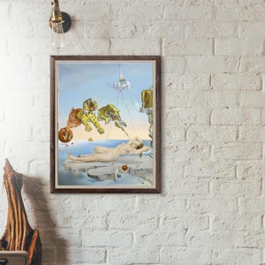 Könnte beinhalten: Ein gerahmter surrealistischer Druck mit einer nackten Figur auf einer schwimmenden Plattform, mit Tigern und anderen fantastischen Elementen, die im Himmel schweben. Das Kunstwerk ist vor einem blauen Himmel und Ozean in einem braunen Holzrahmen.