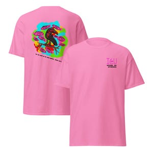 Pode incluir: Duas camisetas rosa com designs gráficos. Uma apresenta uma ilustração de corvo colorido rodeado por olhos, com texto. A outra tem o texto "I&U Weird in Wyoming".