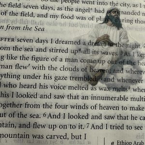 May include: An open book with text and an illustration of a man in white robes. The text includes the title "The Man from the Sea" and chapter 13. The illustration appears to be a religious figure.