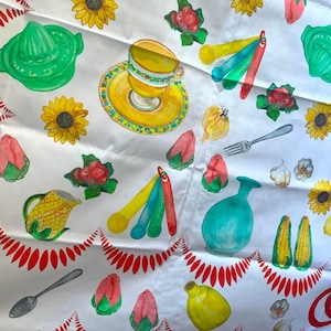 May include: A white tablecloth with a repeating pattern of colorful watercolor illustrations. The design includes sunflowers, teacups, lemons, corn, and other kitchen-themed objects. A red scalloped border frames the design.