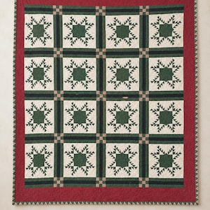 May include: A rectangular quilt featuring a repeating pattern of dark green star motifs on an off-white background. The quilt is framed by a wide, solid red border and separated by dark green and tan grid lines, finished with a small triangular edge.