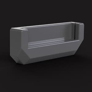 以下が含まれることがあります： 長方形のグレーのプラスチック製の携帯電話ホルダー。上端に盛り上がった縁があり、背面には携帯電話のボタンに簡単にアクセスできる切り抜きがあります。