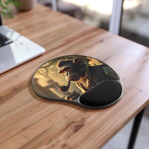 May include: Ergonomic mouse pad with a black wrist rest. The pad features a detailed illustration of a monkey smoking a pipe. The monkey is wearing a suit and is set against a blurred background of trees and sunlight.