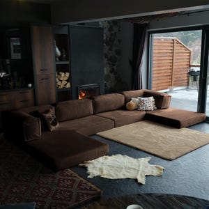 Minimalist comfy sectional displayed with rugs and throws, providing warmth, softness, and versatile everyday use.