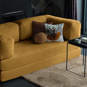 Floor-level teddy sofa styled with layered cushions, creating a warm and welcoming lounge atmosphere.