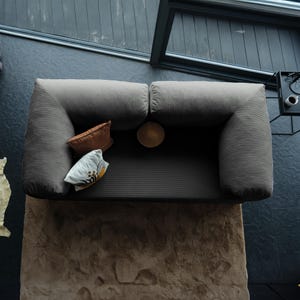 Traditional floor teddy sofa styled in a serene corner with layered textiles, creating a nostalgic space where soft comfort and grounded living meet.