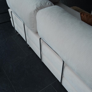Foldable teddy sofa bed displayed in minimalist tones, offering versatile use for both lounging and sleeping.