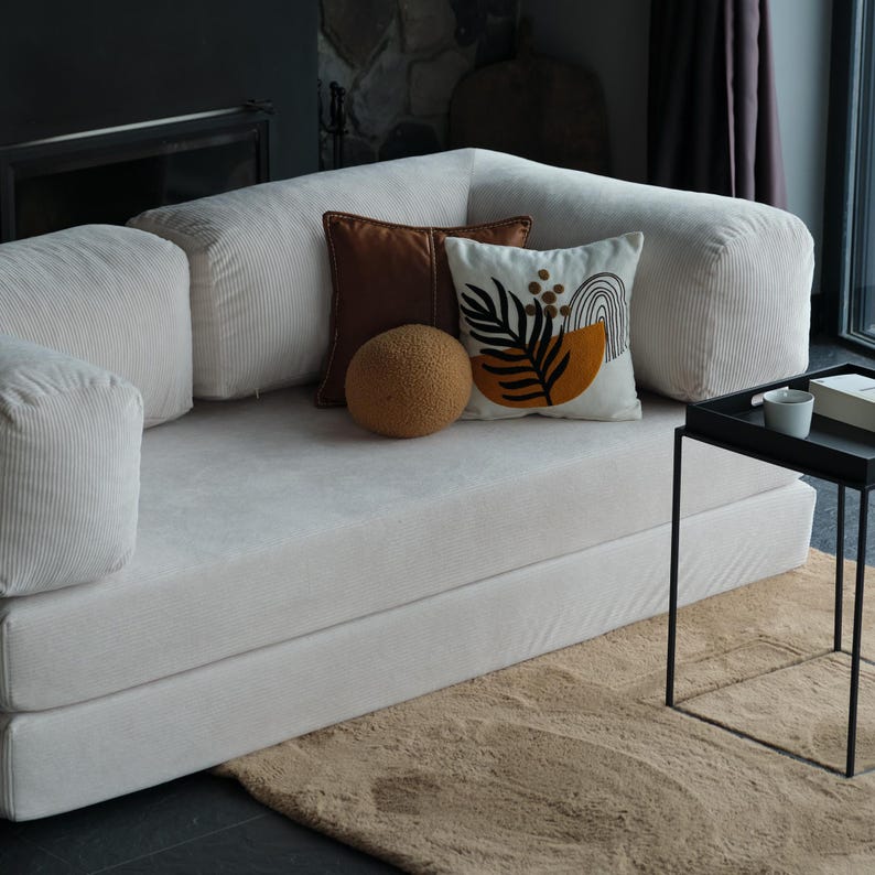 Livingroom soft teddy sofa arranged in a grounded, floor-level layout with layered throws and neutral tones, inviting warmth and daily comfort into your space.