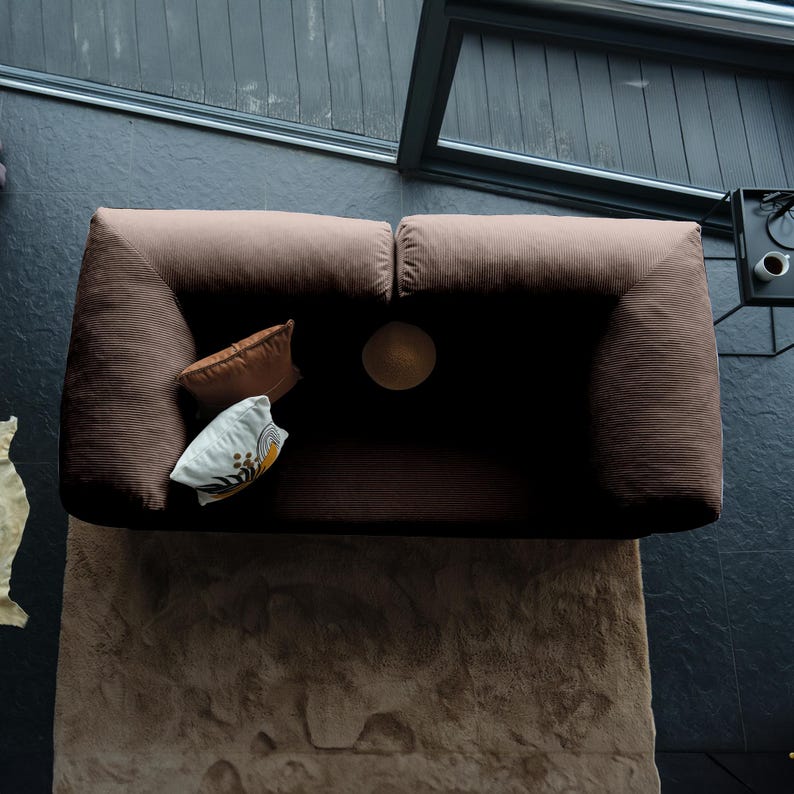 Modular sleeper teddy couch displayed with layered throws, blending cozy comfort with practical multifunctionality.