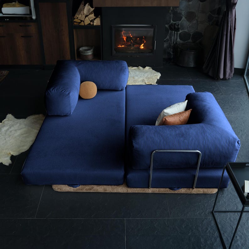 Corduroy foldable sofa styled as a compact guest bed in a minimal interior, showing how small-space living can still be cozy, stylish, and sleep-ready.