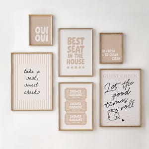 Puede incluir: Una colección de arte mural enmarcados con marcos dorados. El arte presenta varias frases y diseños, incluyendo "OUI OUI", "BEST SEAT IN THE HOUSE", "SO FRESH & SO CLEAN", "take a seat, sweet cheeks", "SHOWER KARAOKE" y "Let the good times roll".
