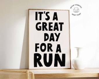 Pode incluir: Uma impressão emoldurada com o texto "IT'S A GREAT DAY FOR A RUN" em letras pretas em negrito sobre um fundo branco. A impressão é exibida em uma superfície de madeira com um vaso branco. Um pequeno ícone indica que é um download instantâneo.