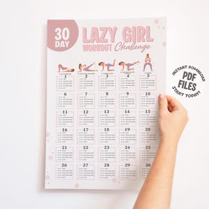 Puede incluir: Un calendario rosa y blanco de 30 días del Desafío de Entrenamiento Lazy Girl. El calendario presenta ilustraciones de poses de entrenamiento y el texto "INSTANT DOWNLOAD PDF FILES START TODAY!". El calendario es sostenido por una persona.