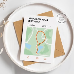 May include: A birthday card with the text "Kudos on Your Birthday" and a map design. The card is on a white tray with a brown envelope. The card also has the text "You're The Local Legend" and "Hope You Have The Best Day".